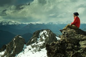 Woman sitting on top of a mountain